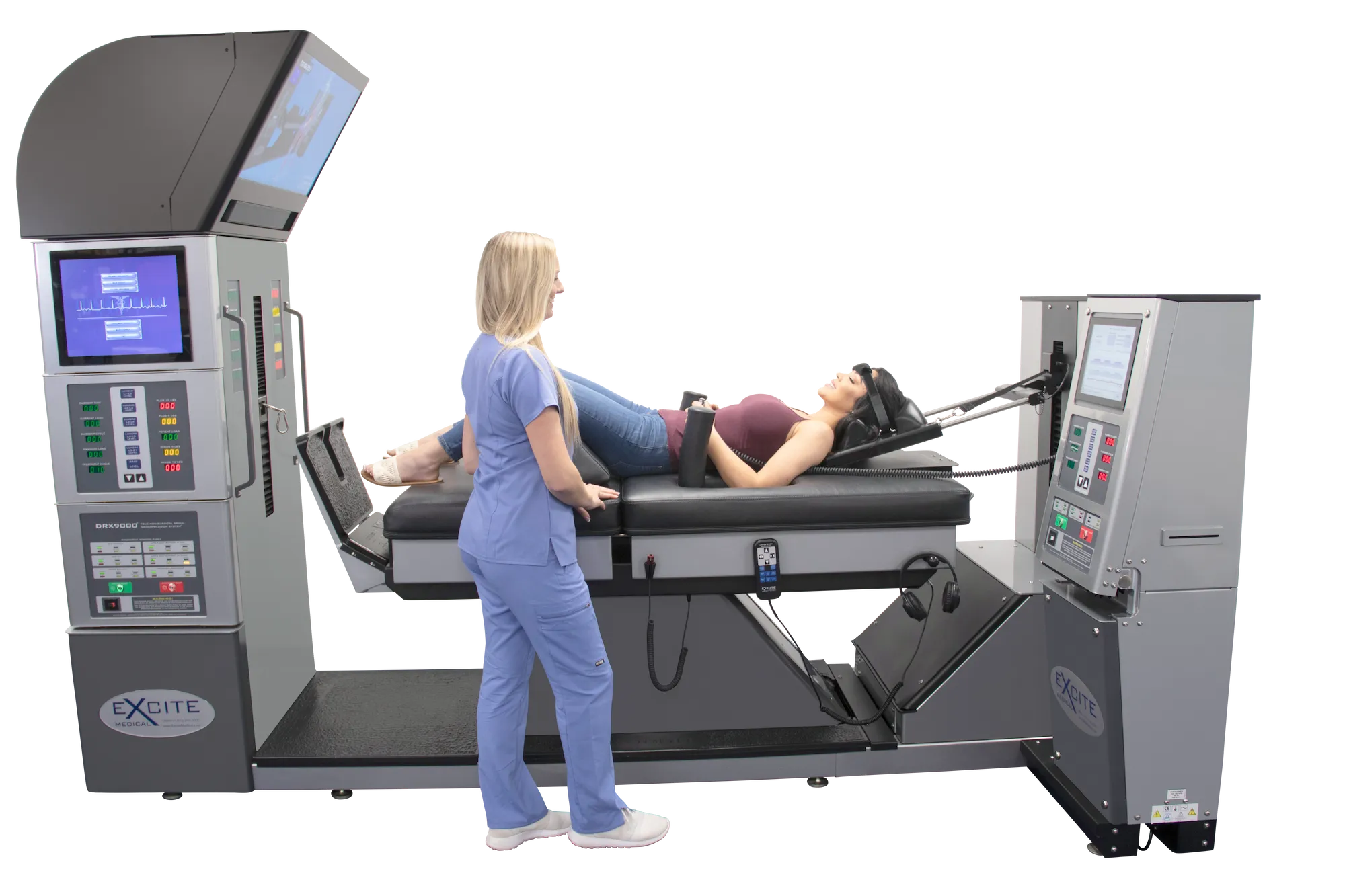 A medical professional in light blue scrubs assists a patient lying on a gray DRX9000 spinal decompression machine with multiple screens and controls.