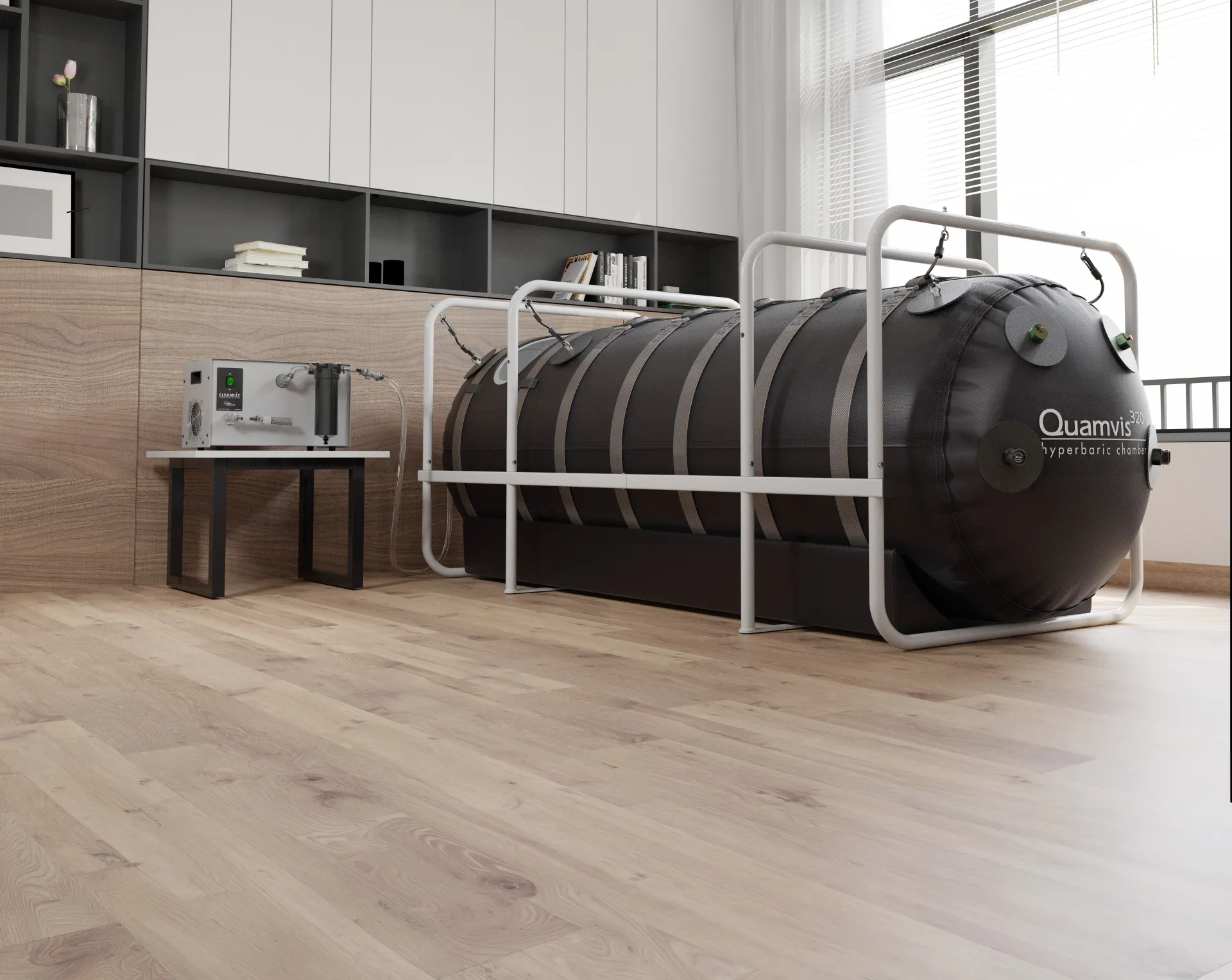 A black Quamvis hyperbaric chamber with a white frame and a control unit in a modern room with wooden floors and built-in shelving.